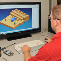 Engineer at a computer making a mold